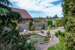 a garden with a pond in front of a house at Haus Berger in Wehr