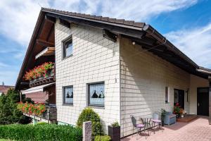 a white house with two windows and a patio at Haus Berger in Wehr