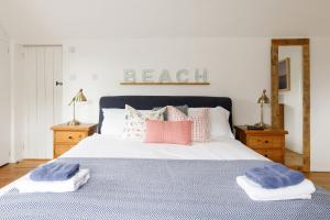 een slaapkamer met een bed met kussens erop bij Family Beach House in Seaside Village with Garden & Parking in East Preston