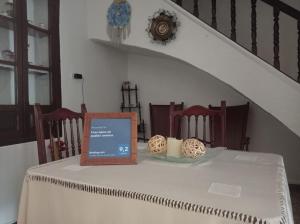 un tavolo con una tovaglia bianca con un cartello sopra di Casa típica de pueblo andaluz a Villanueva de San Juan
