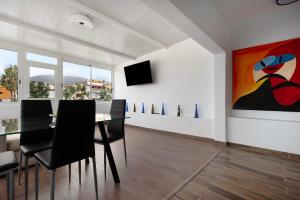 a dining room with a table and a painting on the wall at Ático La Dehesa in Puerto de la Cruz