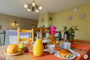 a dining room table with food and orange juice at Les Volets Bleus in Dornes