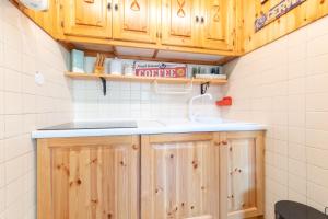 a kitchen with wooden cabinets and a sink at Monolocale ristrutturato in centro paese con wifi AS19 in Breuil-Cervinia