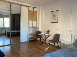 1 dormitorio con 1 cama, mesa y sillas en Apartament WHITE, en Kielce