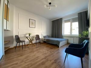 a bedroom with a bed and a table and chairs at Apartament WHITE in Kielce