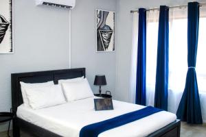 a bedroom with a bed with blue curtains at Mills Pad with 2-bedroom in Nelspruit