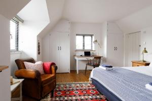 1 dormitorio con cama, silla y escritorio en Family Beach House in Seaside Village with Garden & Parking, en East Preston