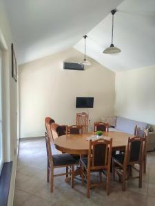 a dining room with a wooden table and chairs at Little village house in Káty