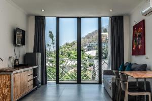 un soggiorno con divano e una grande finestra di Komodo Suites Downtown Managed by CPM Bali a Labuan Bajo