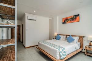 a bedroom with a bed with blue pillows at Komodo Suites Downtown in Labuan Bajo +98 photos