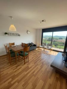 sala de estar con mesa, sillas y ventana grande en Apartamento en Olvan, Berguedà - ALBERGA, en Olvan