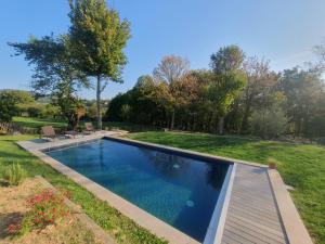 a swimming pool in the yard of a house at Superbe maison 234 m² avec piscine chauffée in Saint-Didier-au-Mont-dʼOr