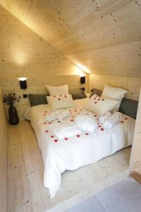 a large white bed in a wooden room at L'Echappée Magique in Mandray