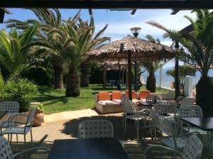 a patio with tables and chairs and an umbrella at Alonaki Beach in Preveza