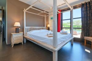 1 dormitorio con cama con dosel y ventana en Daru Dunya, en Beniarbeig