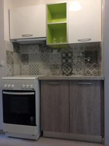 a kitchen with white cabinets and a stove at Alonaki Beach in Preveza