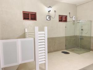 FARONA Beach Villa في أمبارا: حمام مع دش وباب زجاجي