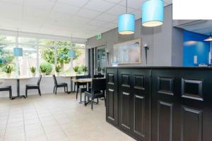 a large room with tables and chairs and blue lights at De Heek in Valkenburg