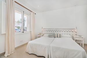 ポルト・ダ・ポリェンサにあるVilla Bambuの白いベッドルーム(大型ベッド1台、窓付)