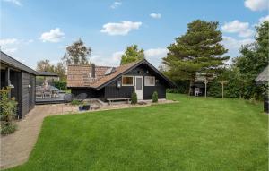 una pequeña casa negra con un patio verde en Gorgeous Home In Sydals With Kitchen, en Skovby