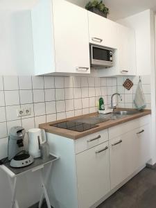 a white kitchen with a sink and a microwave at Alissa in Ludwigsburg +21 photos
