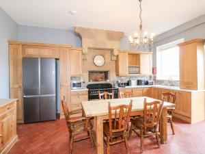 a kitchen with a table and chairs and a refrigerator at The Cottage in Belper +14 photos