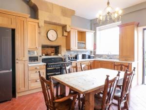 a kitchen with a wooden table and a dining room at The Cottage in Belper