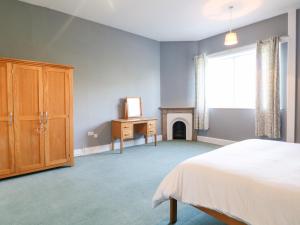 a bedroom with a bed and a dresser and a fireplace at The Cottage in Belper