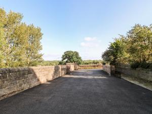 a stone bridge over a road next to trees at The Cottage in Belper