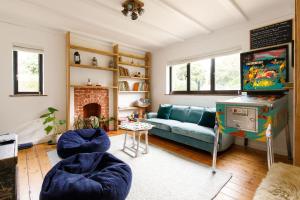 een woonkamer met een blauwe bank en een videospel bij Family Beach House in Seaside Village with Garden & Parking in East Preston