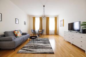een woonkamer met een bank en een tv bij Vienna City Apartments Krongasse in Wenen