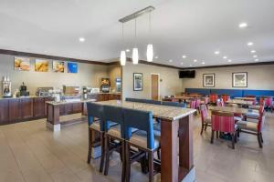 a restaurant with tables and chairs and a cafeteria at Comfort Inn La Porte in LaPorte