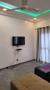 a living room with a flat screen tv and a couch at Superbe appartement une chambre salon à Cotonou in Cotonou