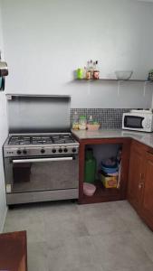 a kitchen with a stainless steel stove and a microwave at Superbe appartement une chambre salon à Cotonou in Cotonou