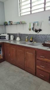 a kitchen with wooden cabinets and a sink at Superbe appartement une chambre salon à Cotonou in Cotonou