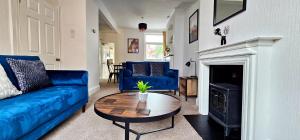 ein Wohnzimmer mit einem blauen Sofa und einem Tisch in der Unterkunft Vale House by Switchback Stays in Cardiff