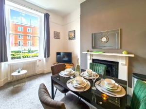 a living room with a dining table and a fireplace at Margaret's Ground in Cheltenham