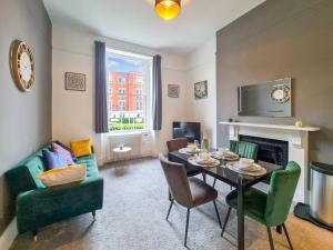 a living room with a table and chairs and a couch at Margaret's Ground in Cheltenham