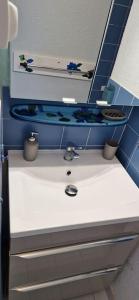a bathroom with a sink and a blue tile wall at la crique in Collioure