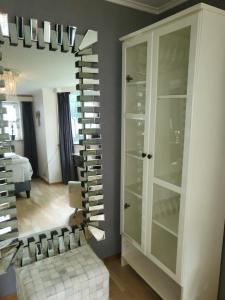 Habitación con espejo y armario con copas de vino. en TT Mansion, en Oslo