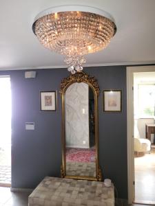 a large mirror in a room with a chandelier at TT Mansion in Oslo