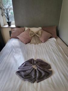 a robe on a bed with a bow on it at TT Mansion in Oslo