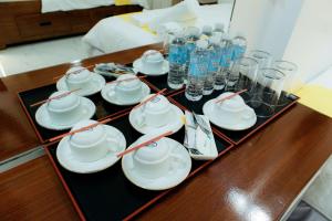 a table with a group of cups and saucers on it at AMYLIE INN in Liloy