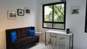 uma sala de estar com um sofá e uma janela em TrevizZo N.urban Pinheiros em São Paulo