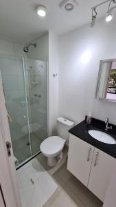 uma casa de banho com um WC, um chuveiro e um lavatório. em TrevizZo N.urban Pinheiros em São Paulo