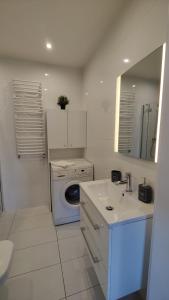 a white bathroom with a washing machine and a sink at Apartament Madelain in Jelenia Góra