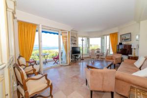 uma sala de estar com um sofá e uma mesa em Residence Les Voiles Blanches - Postcard view on the Croisette em Cannes