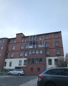 a large brick building with cars parked in front of it at Studio-Apartementwohnung in Kassel
