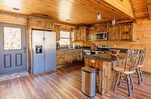 a kitchen with wooden cabinets and a refrigerator at The Preserve Mountain Getaway Cabin in Aquone