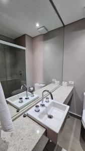 un baño con lavabo y espejo en TrevizZo Haddock Lobo, en São Paulo